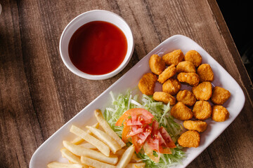Nuggets de pollo con ensalada de lechuga con jitomate y papas a la francesa 