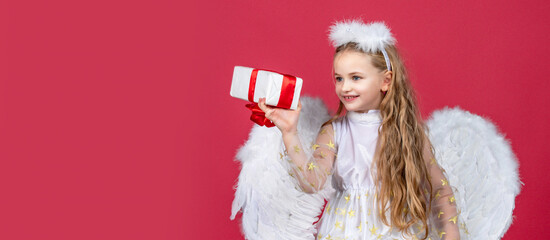 Obraz premium Valentines day banner with angel child. Angel children girl with white wings. Angel kids with present gift, studio portrait. Horizontal photo banner for website header design