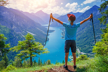 Hiker in the Alps. Boy backpacker tourist hiking at Lake. - 560880127