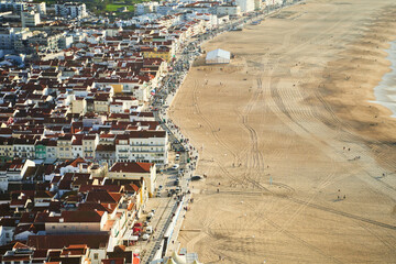 View Nazare beach riviera with cityscape of Nazare town at sunny weather. Portugal. High quality photo