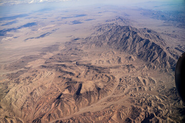 Fototapeta na wymiar By flying to Los Angeles, you can see the sky over the Nevada deserts. The deserts lead to places like Hoover Dam, Valley of Fire, Lake Mead, Red Rock Canyon, Zion National Park, and the Grand Canyon.