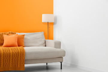 Fototapeta na wymiar Stylish room with cosy sofa near orange wall. Interior design