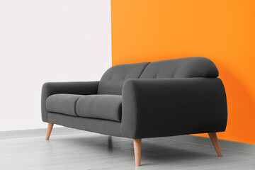 Stylish room with cosy sofa near orange wall. Interior design