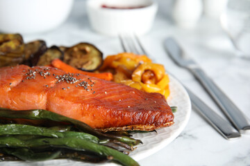 Tasty cooked salmon and vegetables served on white table, closeup. Healthy meals from air fryer
