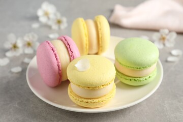 Delicious colorful macarons on grey table, closeup
