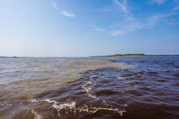 View of the The Meeting of Waters, the confluence between the dark Rio Negro and the pale Solimoes River - Amazonas, Brazil