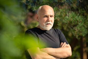 Grandpa. Portrait of serious expression old senior man crossed arms outdoor. Mature man with serious expression on face.