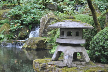 Japanese stone lantern by a waterfall
