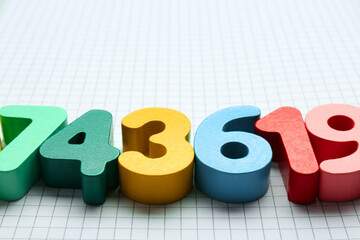 Colorful numbers on notebook with grid pages. Space for text