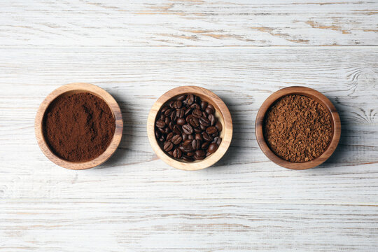 Instant, ground coffee and roasted beans on white wooden table, flat lay