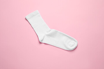One white sock on pink background, top view