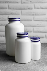 White medical bottles on light gray textured table