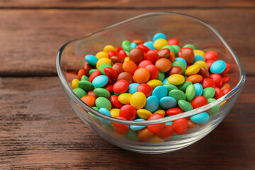 Tasty colorful candies on wooden table, closeup