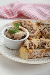 Tasty sandwiches with cod liver and parsley on white wooden table