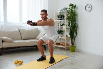 Man sports home training on the floor on a mat with dumbbells, exercises for muscle growth, pumped...