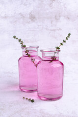 Pink drink with thyme in a glass