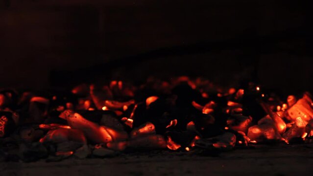 Black Stainless Steel Charcoal Rake Moving Burning Charcoal While a Man is Preparing an "Asado", Traditional Barbeque in the Argentine Pampas. 4K Resolution.