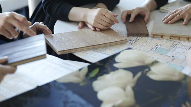 建築素材と資材を選ぶ会議中の人々の手と資料