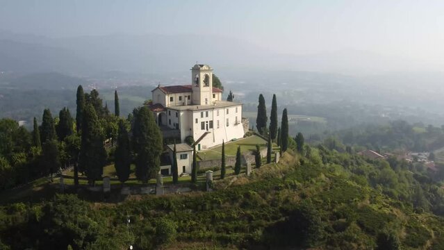 Cinematic, unedited aerial view of Montevecchia Santa Maria del Carmelo sanctuary on the hill top. Panning shot.