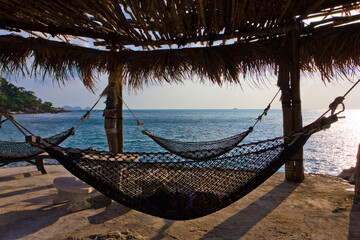Hammock and sun beds on a perfect tropical beach in Phangan island, Thailand.