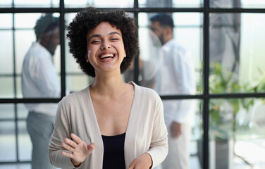 business woman with her staff in background at office