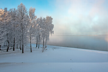 Winter morning landscape with river, water, forest and steam on the water. Christmas sketch.