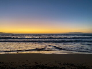 Fototapeta premium Beautiful sunset glow over waves in Maui, Wailea beach