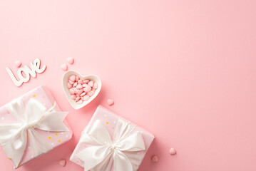 Valentine's Day concept. Top view photo of present boxes with white ribbon bows heart shaped saucer with sprinkles and inscription love on isolated pastel pink background with copyspace