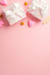 Valentine's Day concept. Top view vertical photo of present boxes with ribbon bows decorative clips heart shaped candles straws and golden sequins on isolated pastel pink background with empty space
