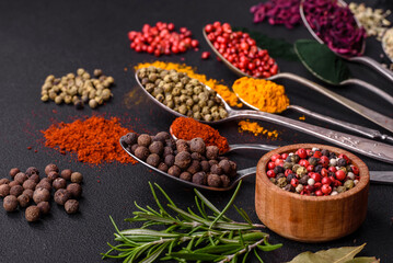Several types of spices in metal spoons paprika, tomatoes, curry, beets, cumin, turmeric, fennel, spirulina