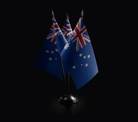 Small national flags of the Australia on a black background