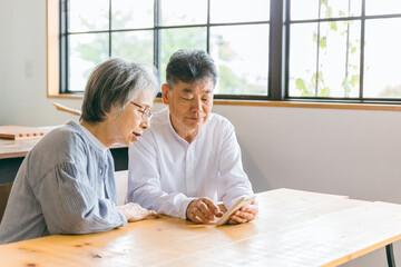 スマホ・スマートフォンのアプリを使うアジア人高齢者夫婦