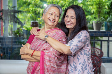 Portrait of happy young indian daughter hug her mother at home, Love and bonding, Asian family. - obrazy, fototapety, plakaty
