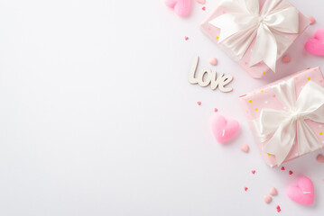 Valentine's Day concept. Top view photo of pastel pink gift boxes with silk ribbon bows heart shaped candles sprinkles and inscription love on isolated white background with blank space