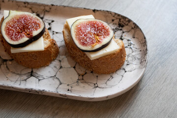 Sandwich with figs and cheese on a marble plate