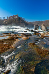Fototapeta na wymiar Rhine Falls or Rheinfall, Switzerland panoramic view. Tourist boat in waterfall. Bridge and border between the cantons Schaffhausen and Zürich. The Largest waterfall in Europe.