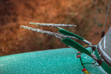 frozen lift up front wind glass wipers on green retro car at winter season - 560953179