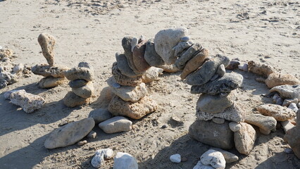 Fototapeta na wymiar Balancing stones on sand. Zen Style Stones by the Sea