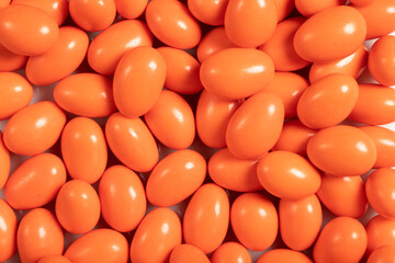 Chocolate dragee in the form of a pile. Orange dragee chocolate with chocolate filling. Top view. close up