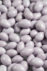 Chocolate dragee in the form of a pile. White chocolate dragee covered with sugar on the outside and filled with chocolate on the inside. close up