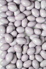 Chocolate dragee in the form of a pile. White chocolate dragee covered with sugar on the outside and filled with chocolate on the inside. Top view. close up