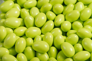 Chocolate dragee in the form of a pile. Green dragee chocolate covered with sugar on the outside and filled with chocolate inside. Close up