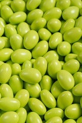Chocolate dragee in the form of a pile. Green dragee chocolate covered with sugar on the outside and filled with chocolate inside. Close up