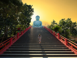 Great Buddha or Kamakura Daibutsu statue at sunset time. The ornate temple stairs. Famous big...