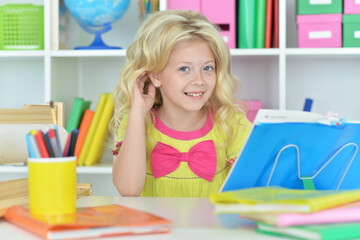 little girl studying at home at the table