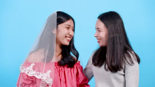 4K, portrait, beautiful asian lgbtq couple, showed off  ring on his girlfriend's left ring finger, which wore diamond ring, Let's get married when, both happy expressions on faces, studio background.
