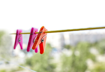 Colorful clothespins against the blurred background. Plastic clothespins in different colors. Blurred image, selective focus