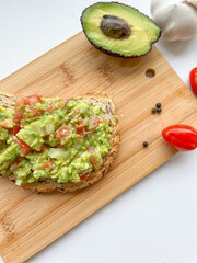 Guacamole toasted on wooden cutting board. Healthy food, diet breakfast