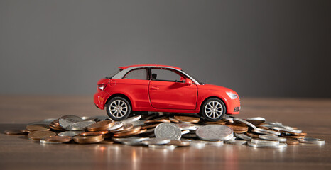 Fototapeta Red toy car and coins on the desk. obraz