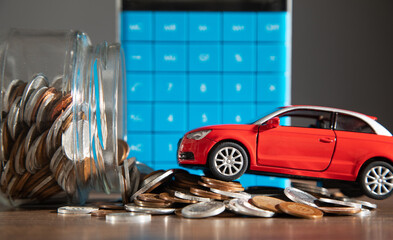 Red toy car and coins on the desk.